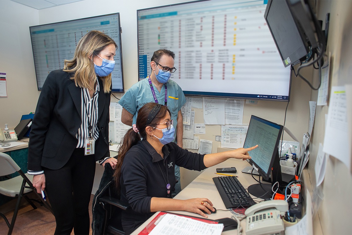 three doctors looking at a monitor